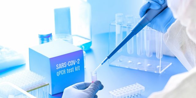 Epidemiologist in protective suit, mask and glasses works with patient swabs to detect specific region of 2019-nCoV virus causing Covid-19 viral pneumonia. Pcr diagnostics kit concept for SARS-CoV-2..